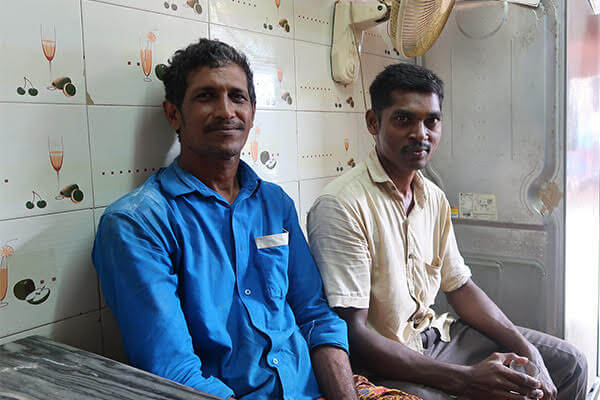 Two men seated and looking at the camera