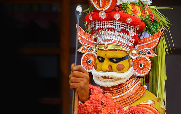 man in decorative make-up, headress and costume